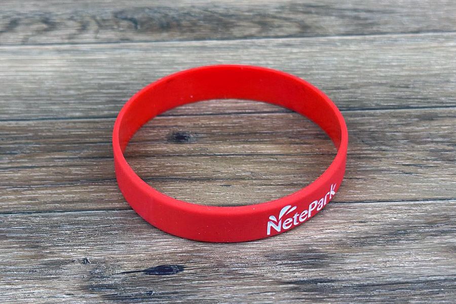 rood siliconen polsbandjes voor Netepark met gravure van het logo en opgevuld met witte inkt